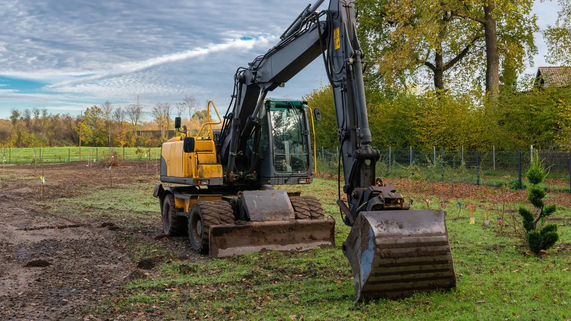 Wheeled excavator standing on a cleared site.
